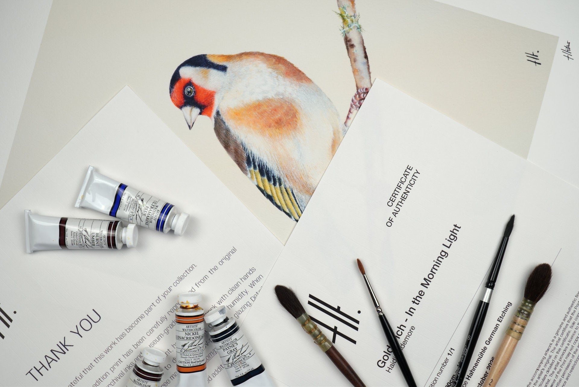A limited edition artist proof of Goldfinch - In the Morning Light on Hahnemühle German Etching paper, part of The Finch Collection by Haidi Hildemore, displayed with a certificate of authenticity and thank you letter.
